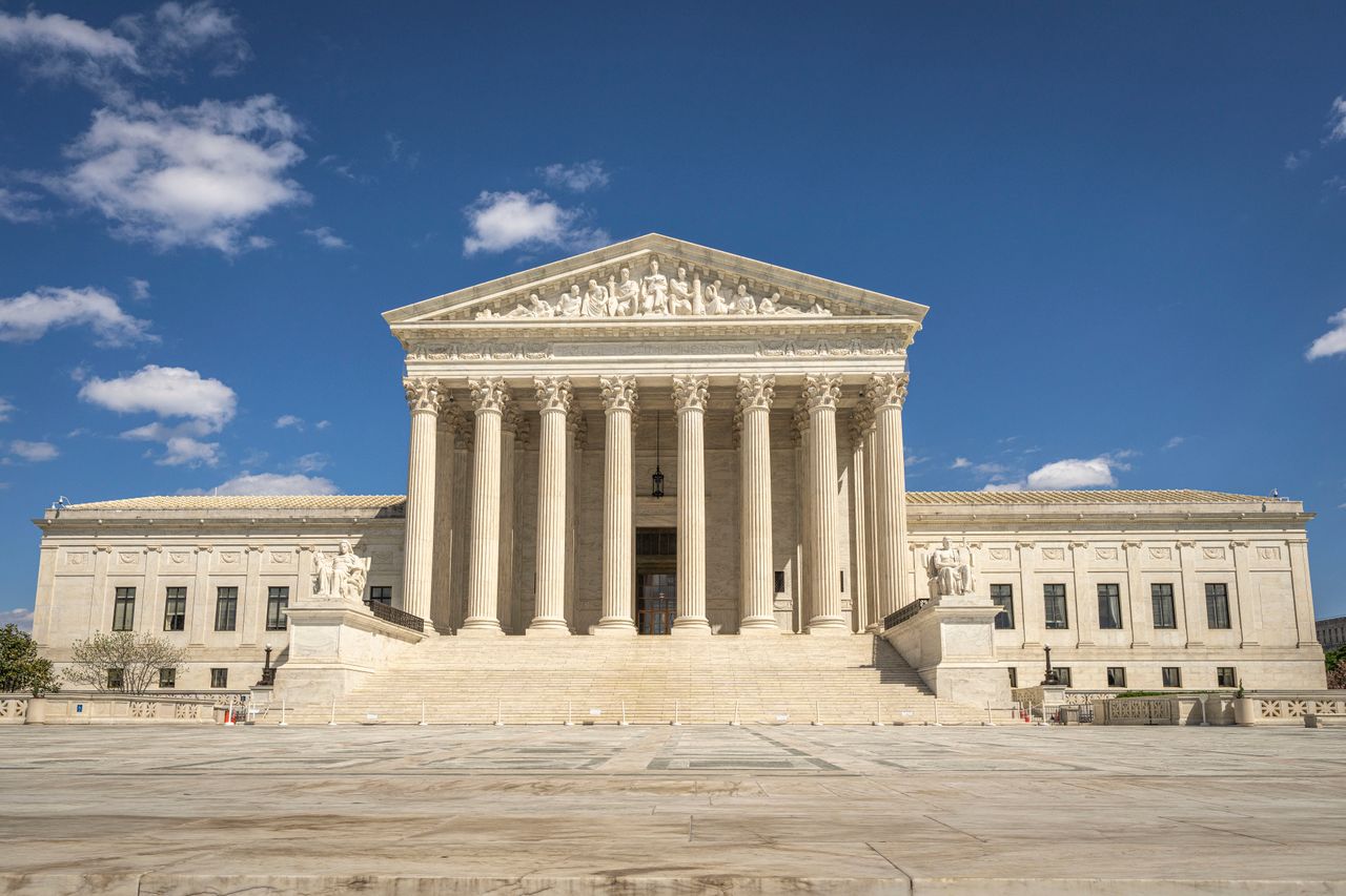 Home The majestic facade of the United States Supreme Court under a clear blue sky.